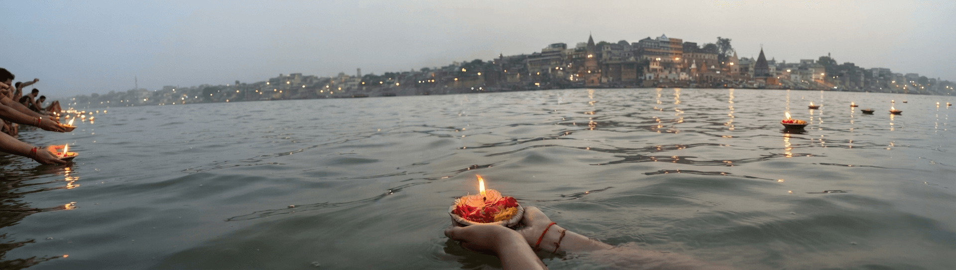 Devotional lamps floating on the Ganges at dusk